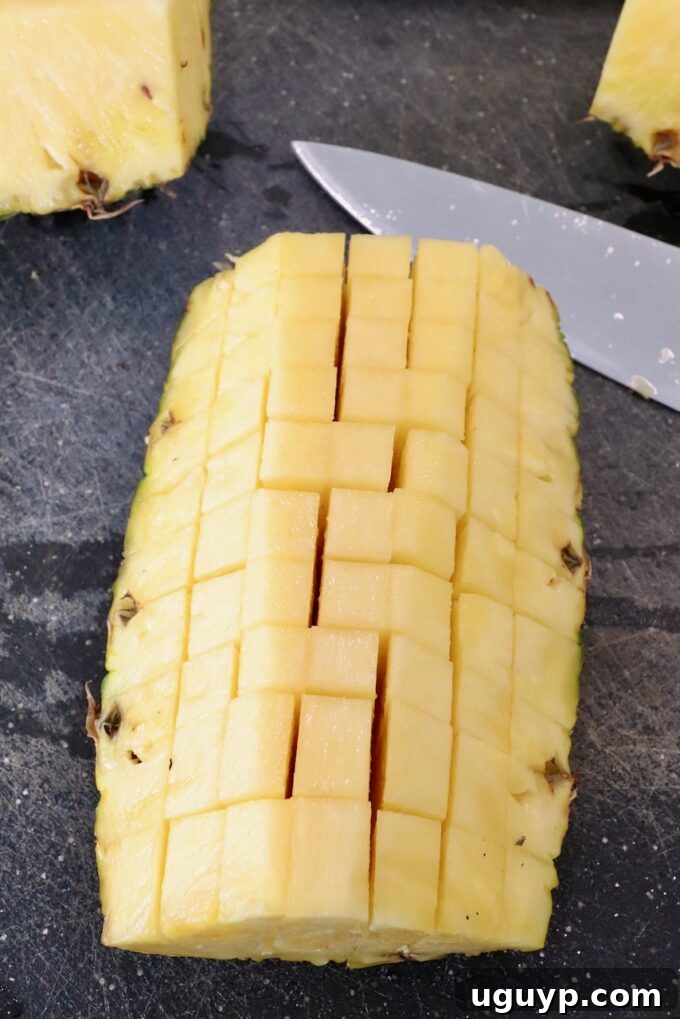 diced fresh pineapple on a cutting board, demonstrating the final cut before mixing