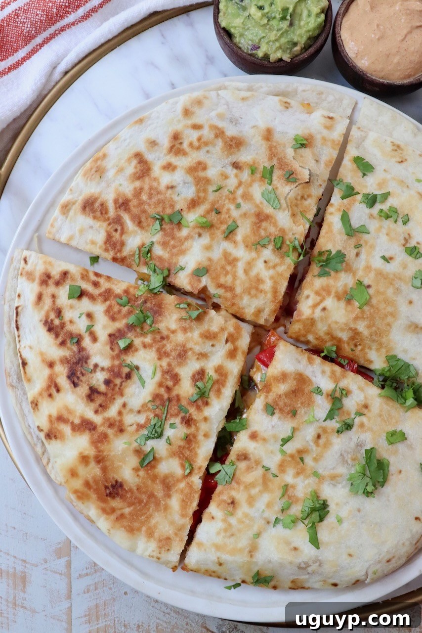 A close-up of a golden-brown chicken quesadilla, cut into quarters, showing the rich, melted cheese and savory filling within. Perfect for sharing or a hearty meal.