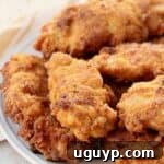 Delicious fried chicken tenders piled up on a plate, ready to be enjoyed.