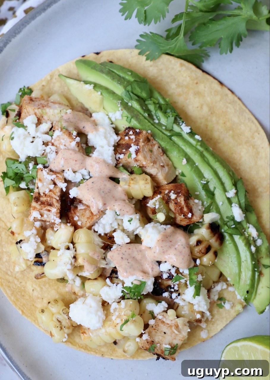 taco on plate topped with avocado and chili lime sauce