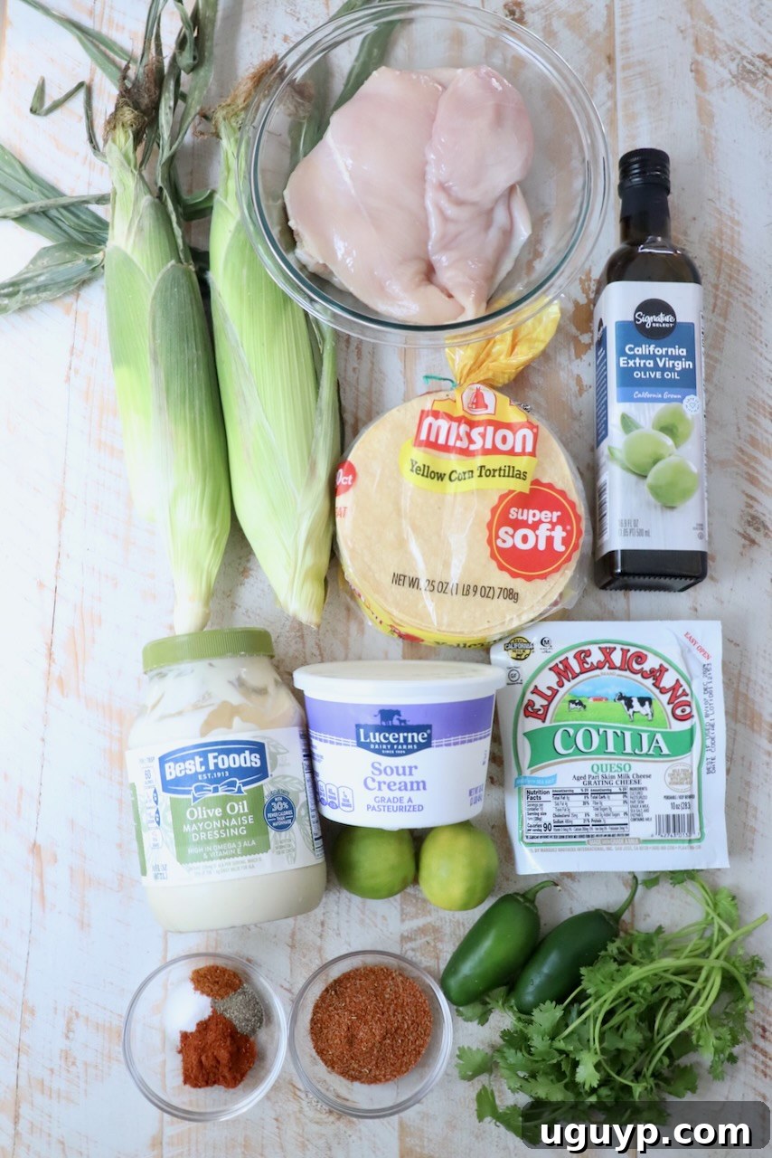 ingredients for chicken street corn tacos on white wood board