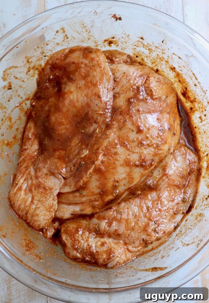 chicken breasts in marinade in glass bowl