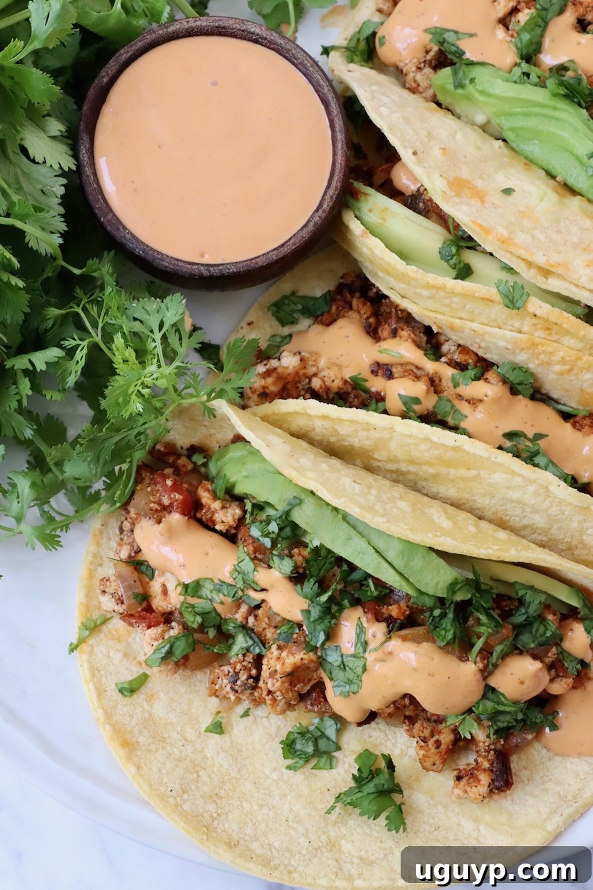 crumbled tofu tacos on plate topped with chipotle sauce