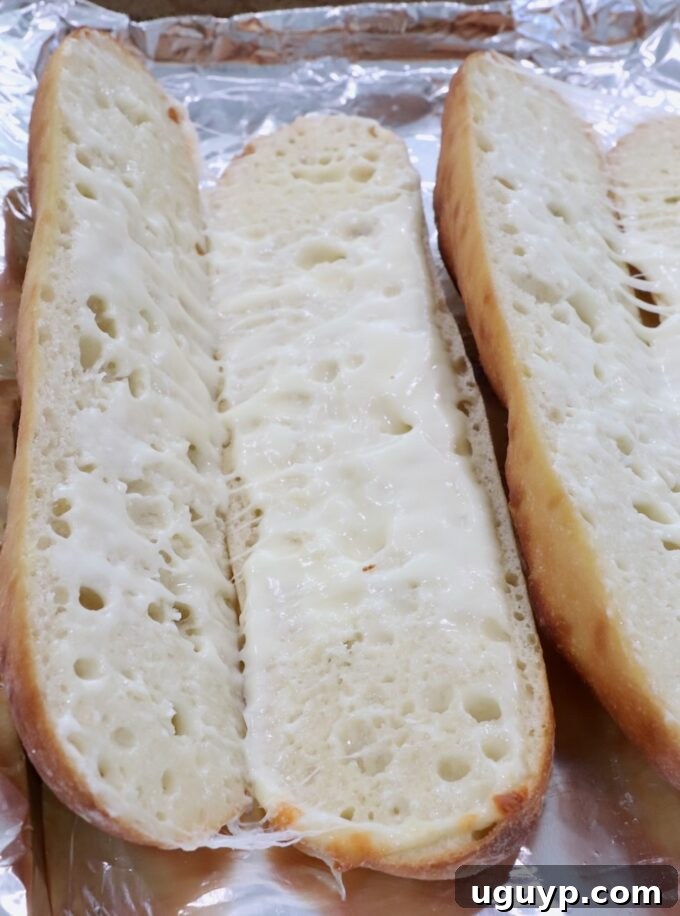 Melted mozzarella cheese creating a delicious base inside a toasted baguette.