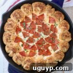 pizza dip in a skillet with pull apart bread surrounding the dip