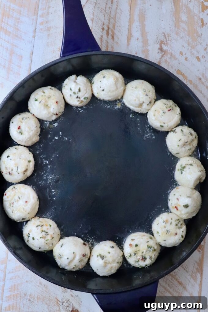 balls of seasoned dough in a cast iron skillet