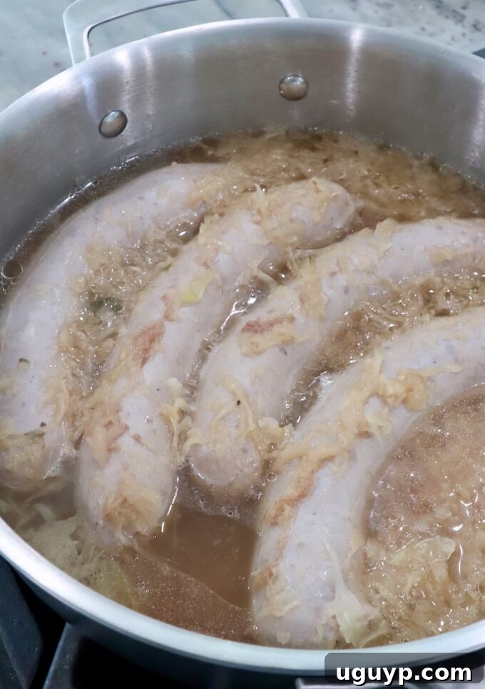 cooked bratwurst in pan with beer and sauerkraut
