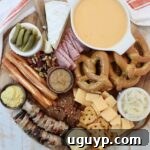 Oktoberfest themed charcuterie board with cheese, pretzels and mustard in small bowls, ready for a festive gathering.