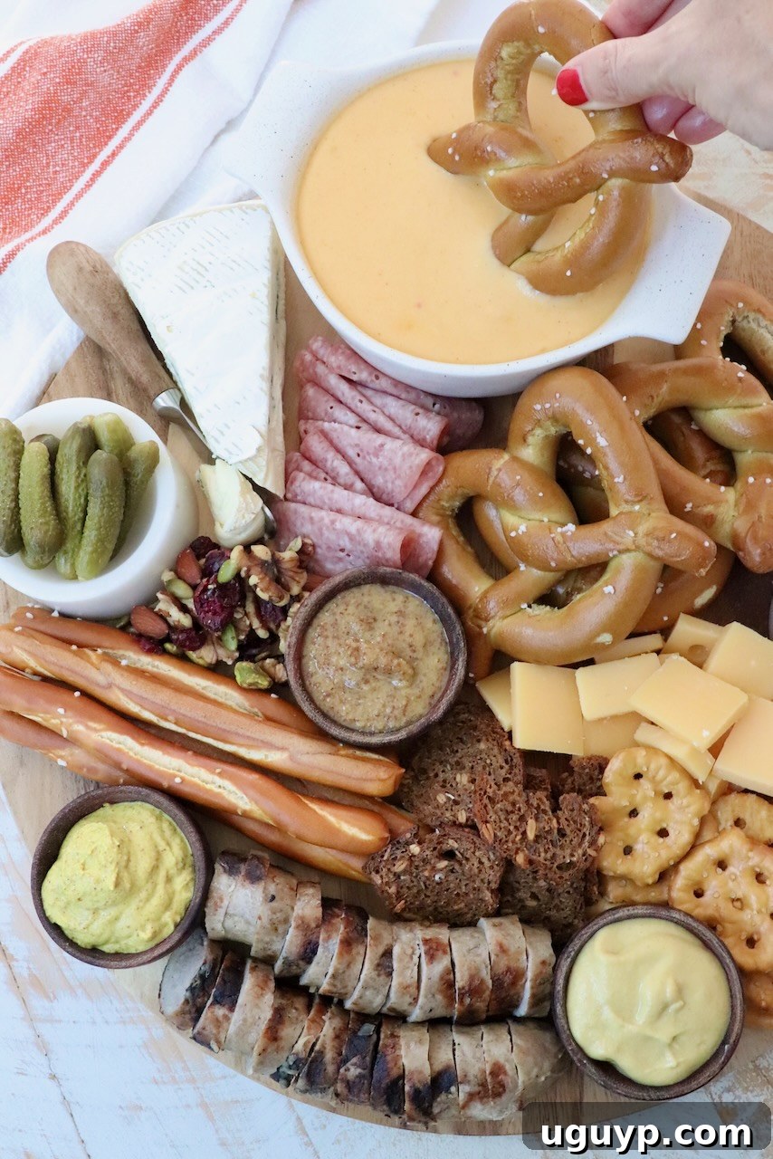 Oktoberfest charcuterie board with soft pretzel dipped in beer cheese dip