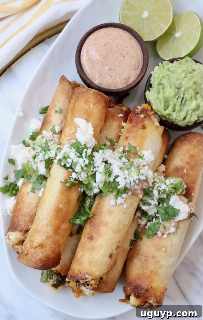 Stacked cooked taquitos on a plate, garnished with fresh guacamole, cotija cheese, and cilantro