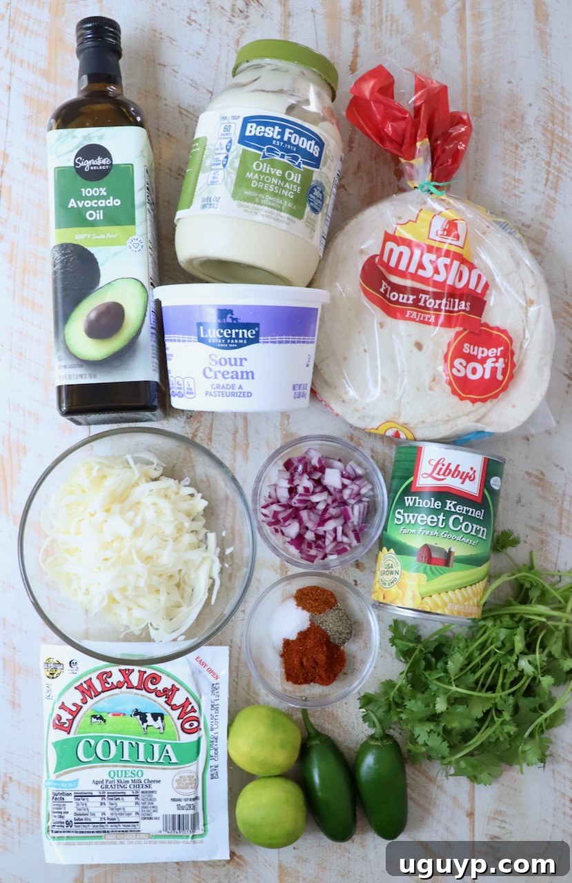 Fresh ingredients for Mexican street corn taquitos artfully arranged on a white wood board