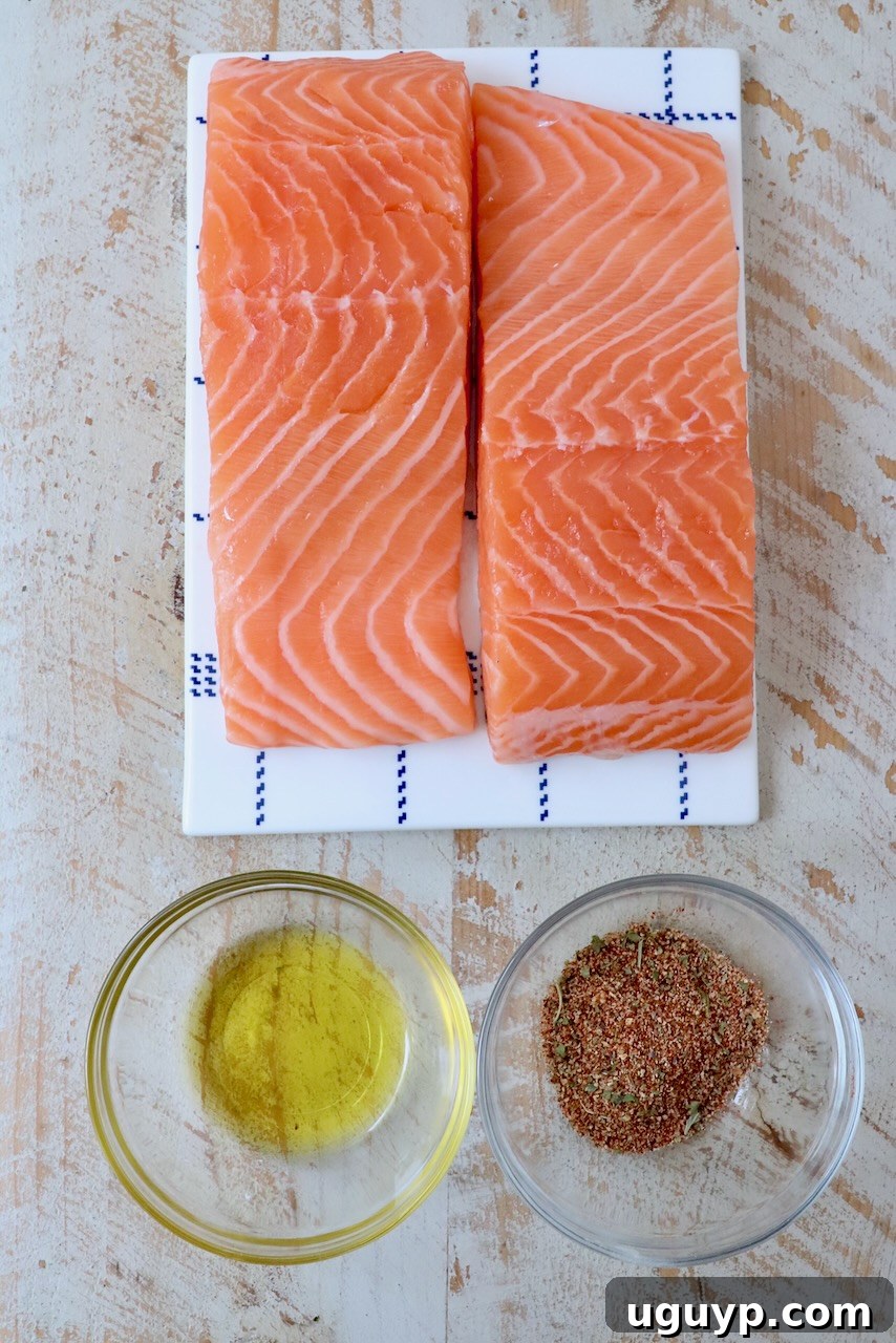 salmon filets next to small bowl of seasoning and small bowl of oil
