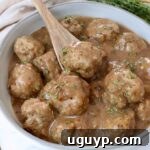Juicy turkey meatballs generously coated in rich brown gravy, served in a bowl with a spoon, ready to be enjoyed.