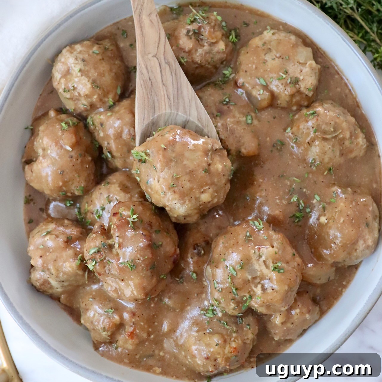 A close-up of turkey meatballs bathed in luscious brown gravy, inviting you to take a bite.