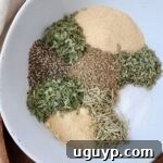 A bowl with the separated ingredients for homemade pot roast seasoning, highlighting the individual spices before mixing.
