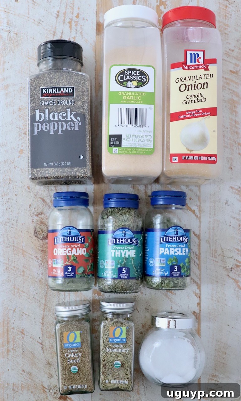 A collection of various dried herbs and spices, some in jars, arranged aesthetically on a white wooden board, highlighting the quality ingredients for the seasoning.