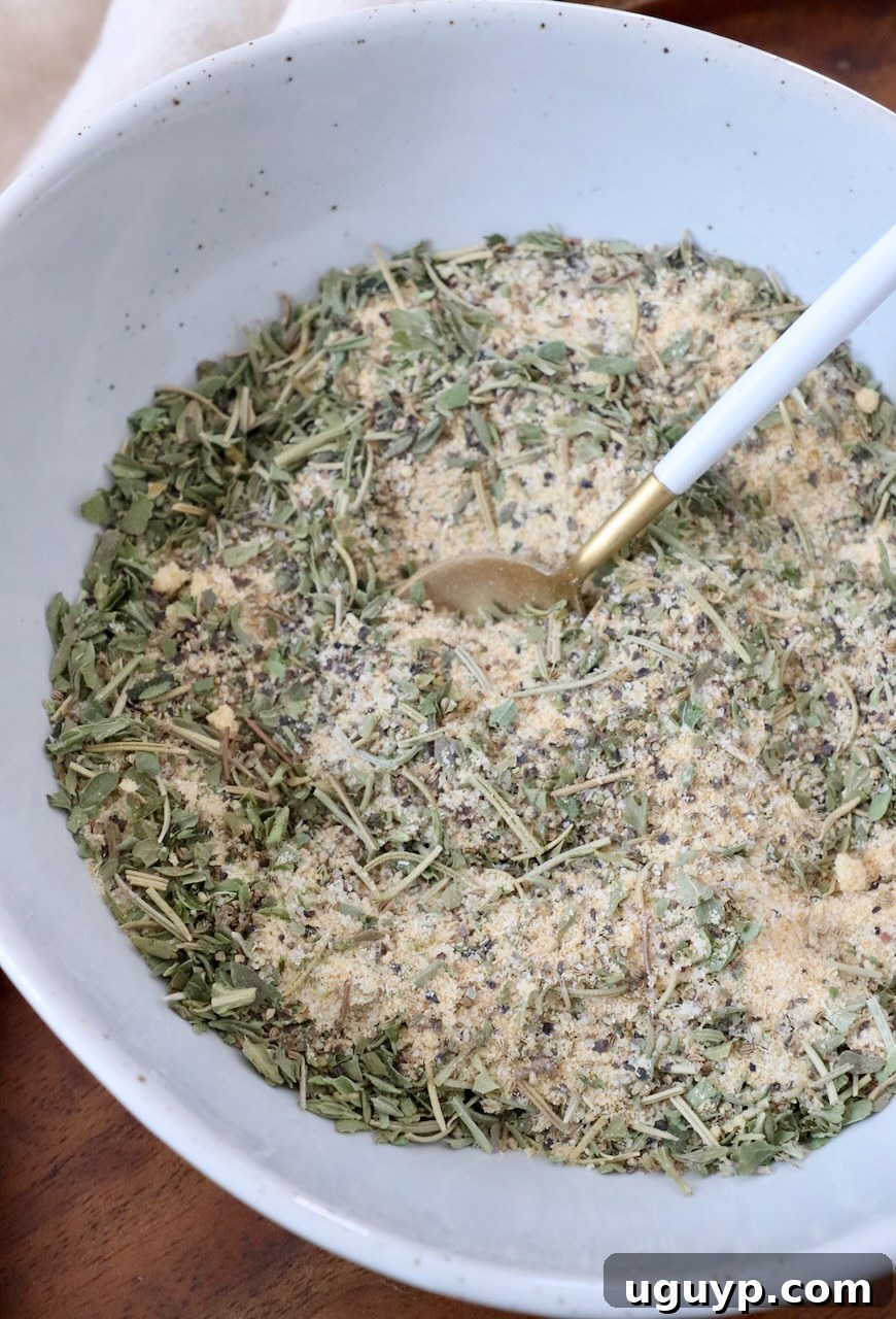 The fully mixed homemade pot roast seasoning blend in a small white bowl, with a measuring spoon resting inside, showcasing its uniform texture.