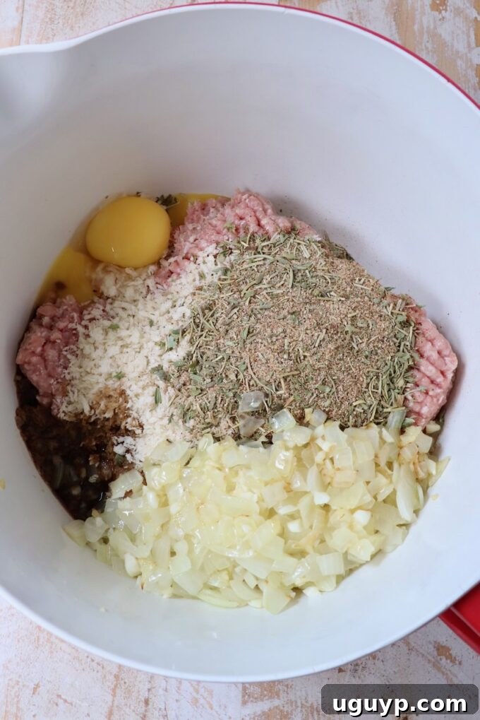 Large mixing bowl filled with ground turkey and other raw ingredients for meatloaf preparation.