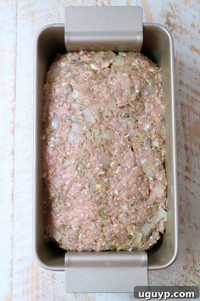 Uncooked turkey meatloaf mixture neatly pressed into a loaf pan, ready for baking.