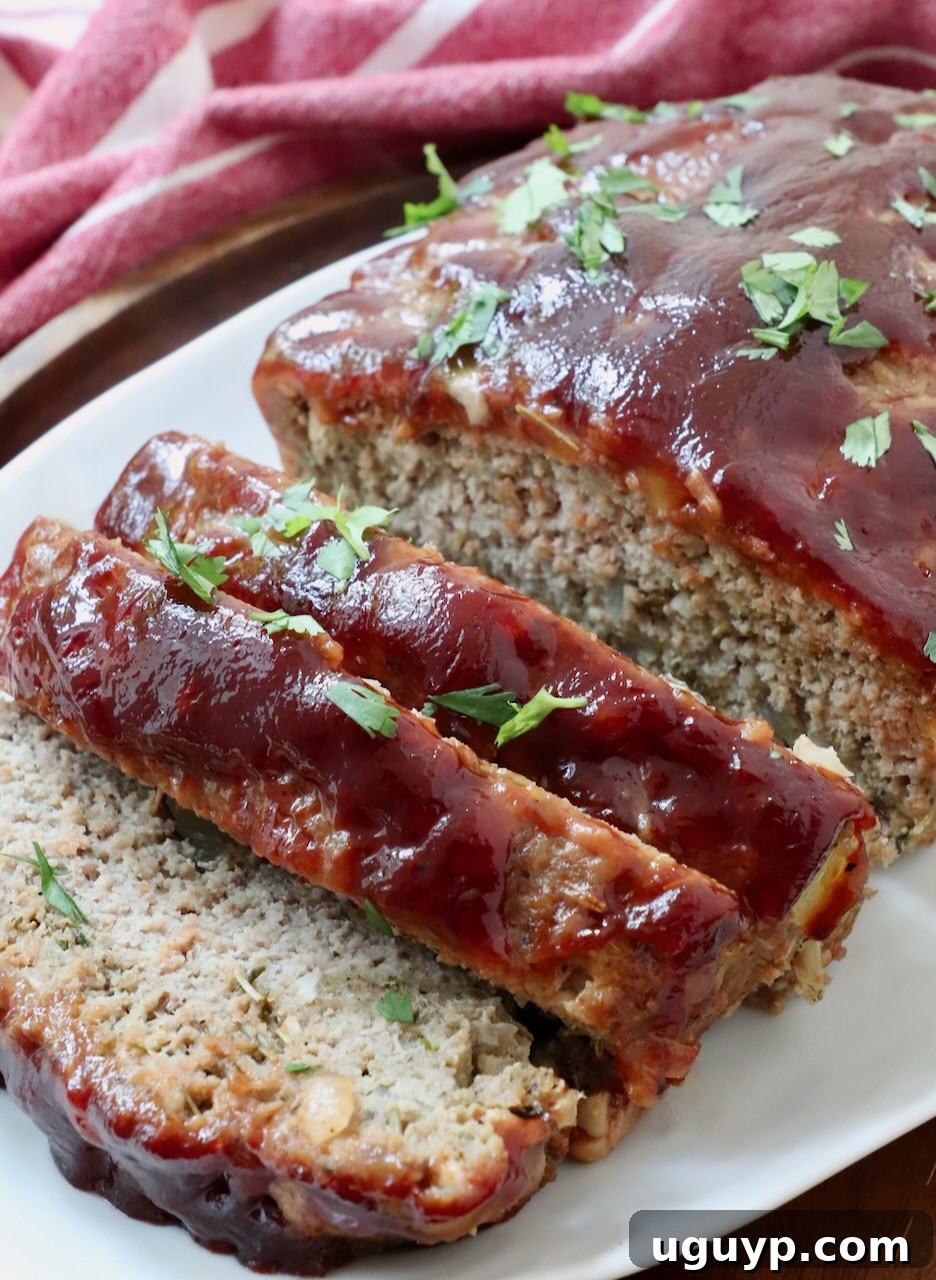 Glazed turkey meatloaf, perfectly sliced and presented on a plate, ready for serving.