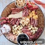 A vibrant charcuterie board filled with an assortment of meats, cheeses, crackers, and fruits, embodying the fall season.