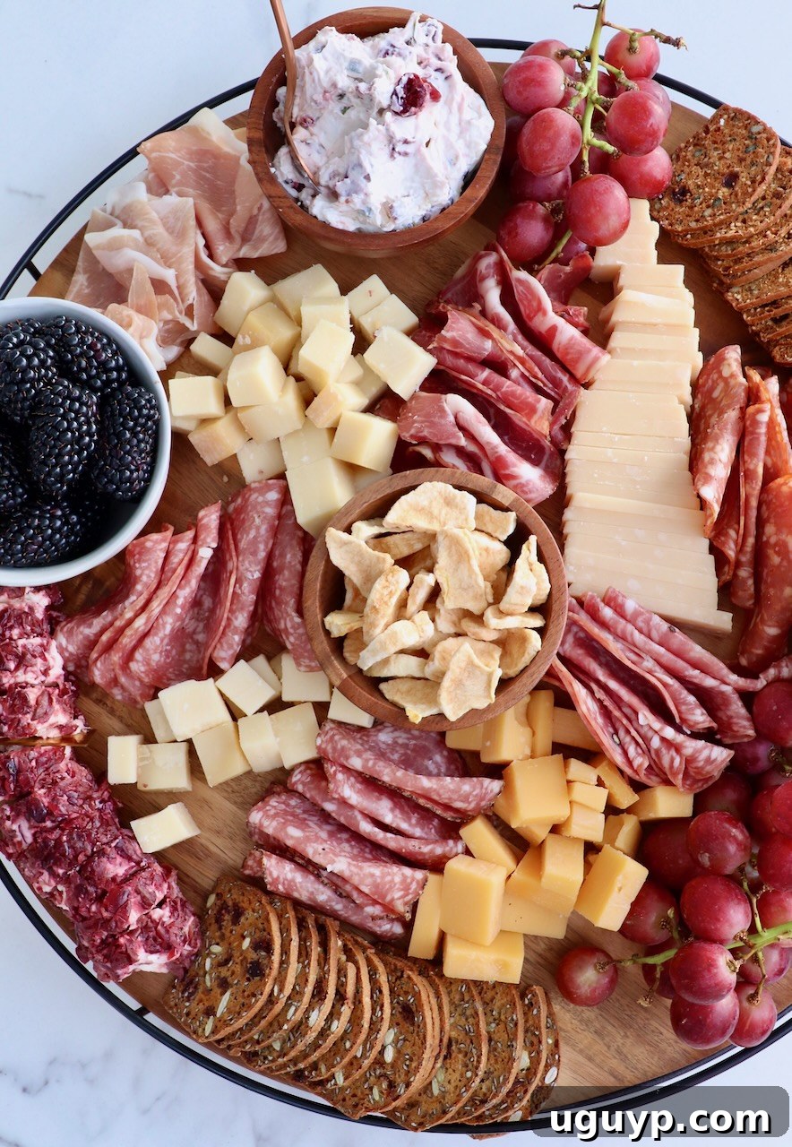 A stunning Fall Charcuterie Board overflowing with an artful arrangement of cured meats, cheeses, dried and fresh fruits, crackers, and a dip, ready to be served.