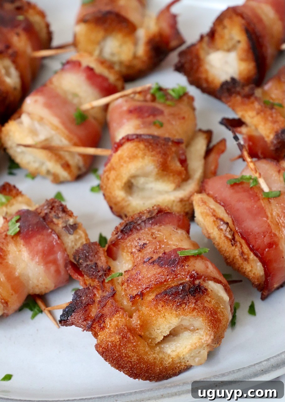A vibrant close-up of crispy bacon roll ups on a white plate, showcasing their golden-brown perfection and inviting texture.