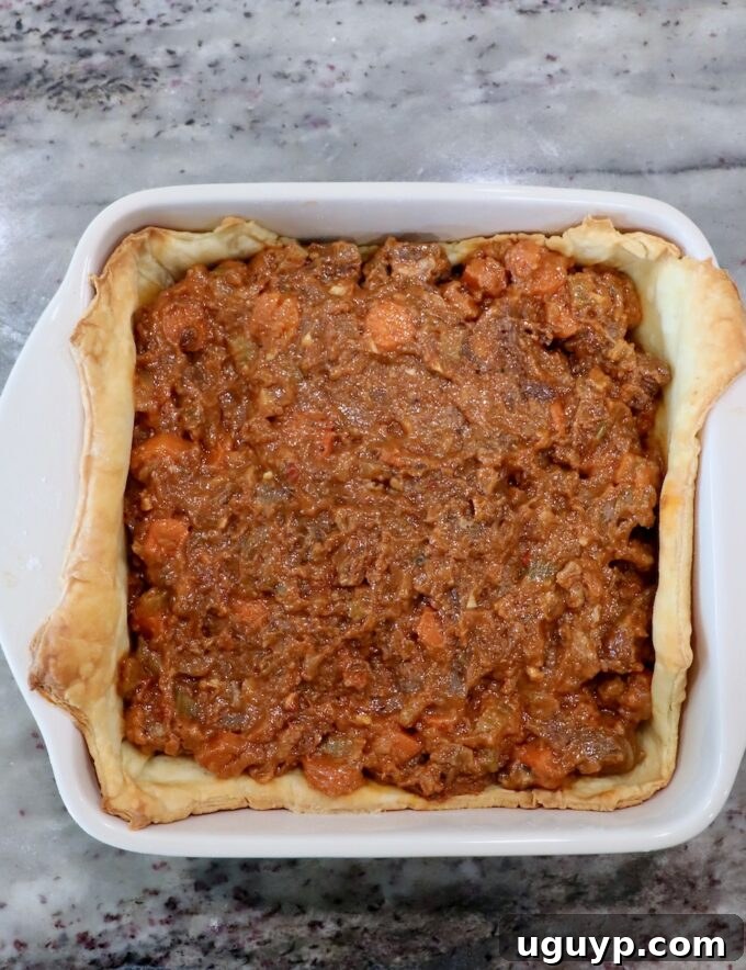 beef filling in a baked puff pastry crust in a baking dish