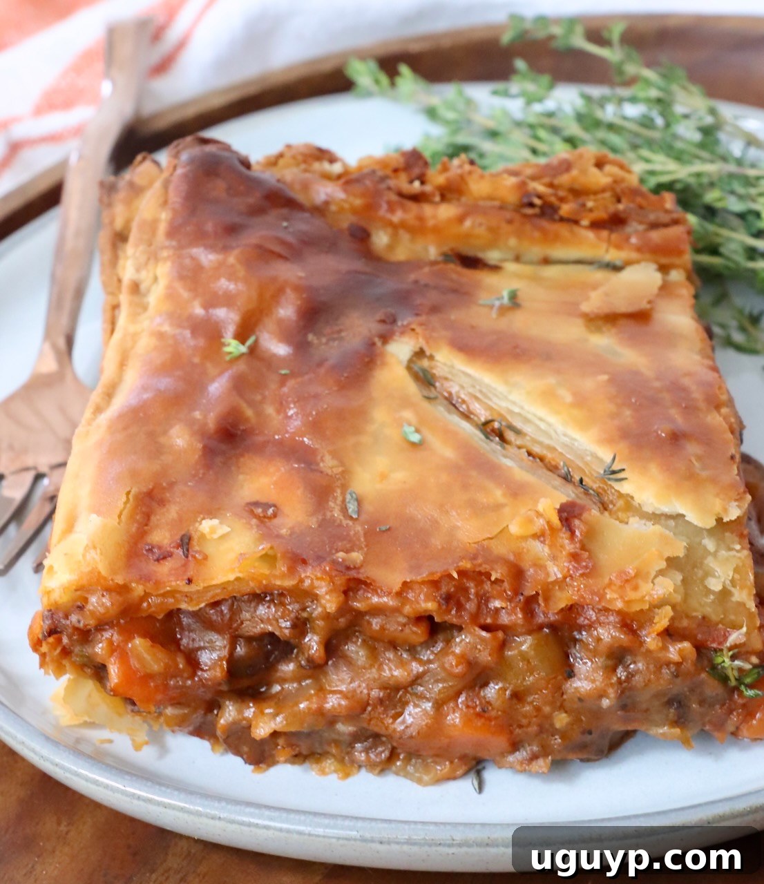 piece of beef pot pie on a plate with a fork