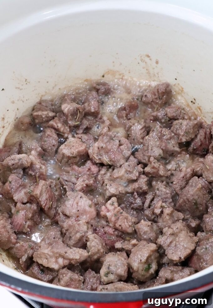 cubes of browned beef chuck roast in a cast iron dutch oven