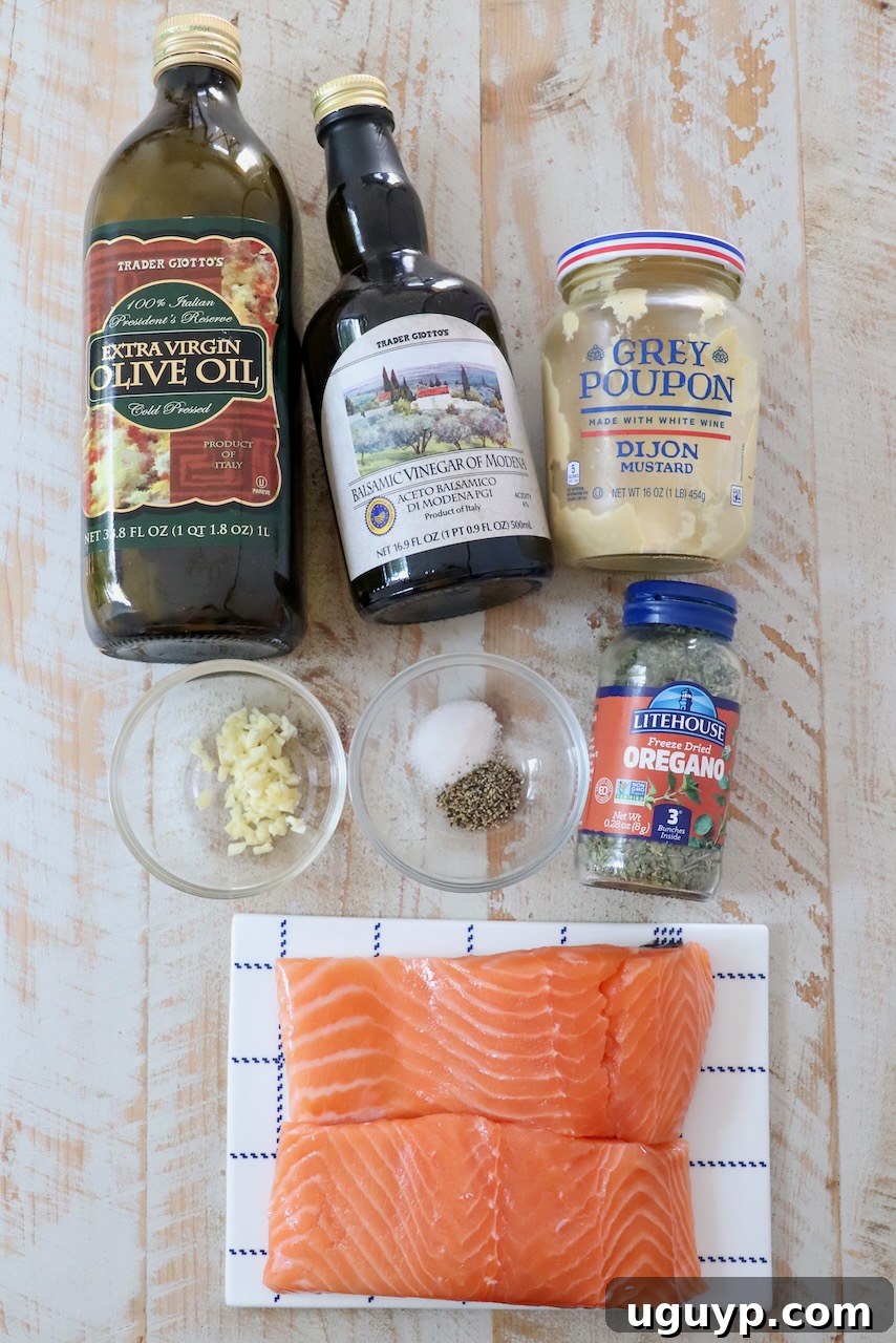 A beautiful flat lay of fresh ingredients for balsamic glazed salmon, including salmon fillets, balsamic vinegar, garlic, olive oil, and herbs, arranged on a rustic white wood board.