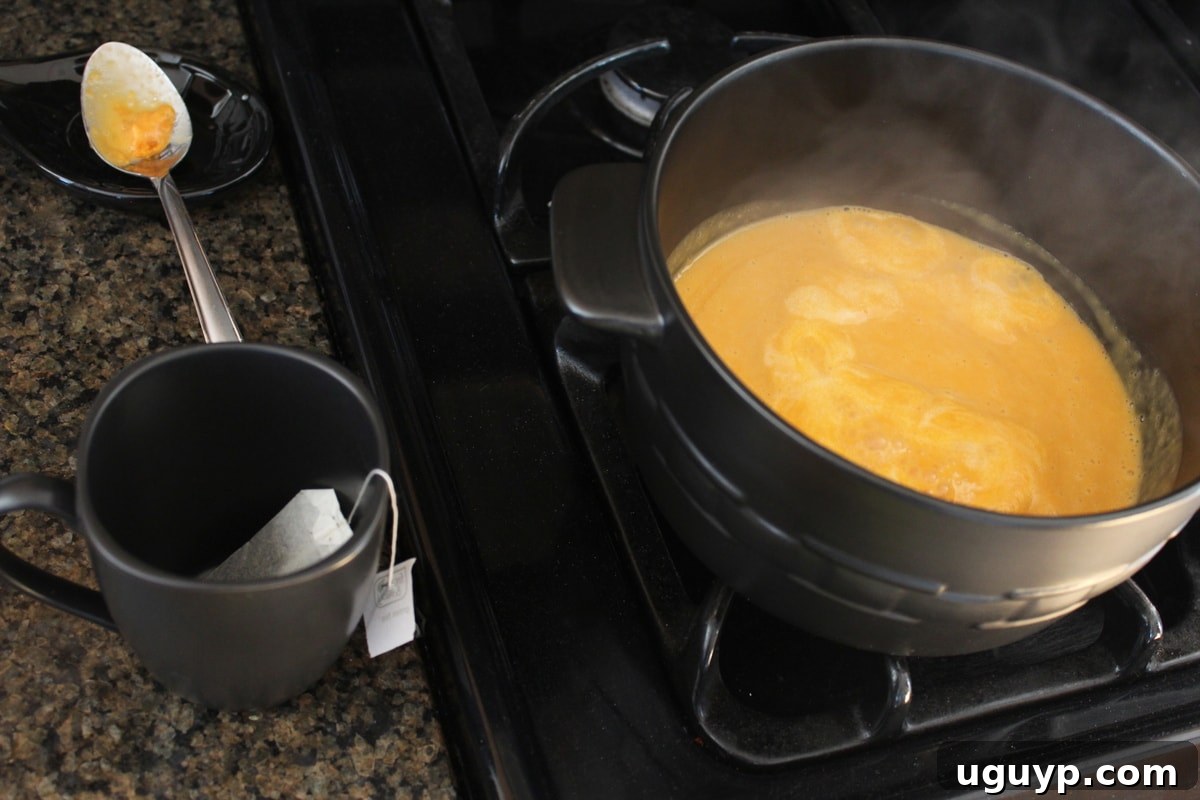 The sweet potato and milk mixture reaching a boil in a small pot, indicating it's ready for the next step of making the latte.