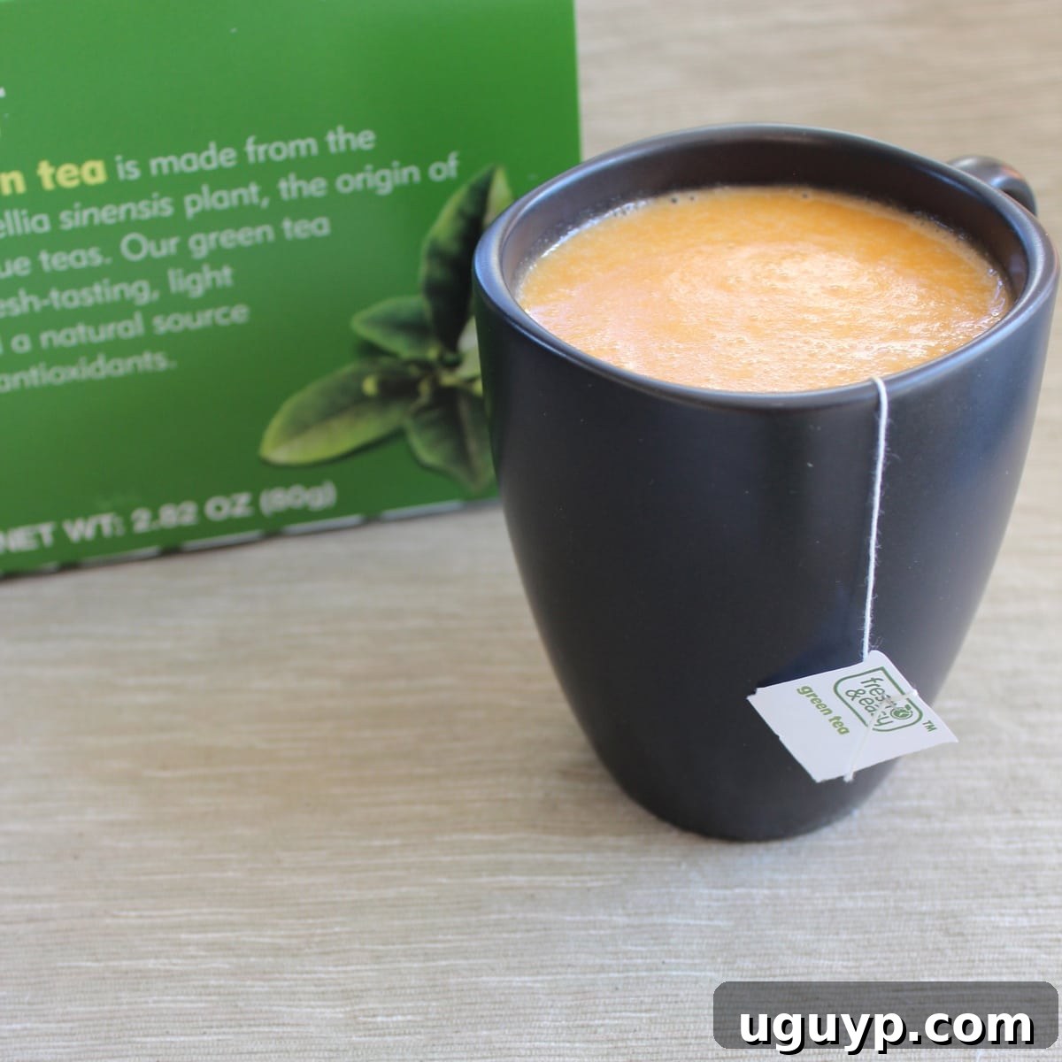 Hot sweet potato mixture poured into a mug with a green tea bag steeping, forming the base of a Sweet Potato Green Tea Latte.