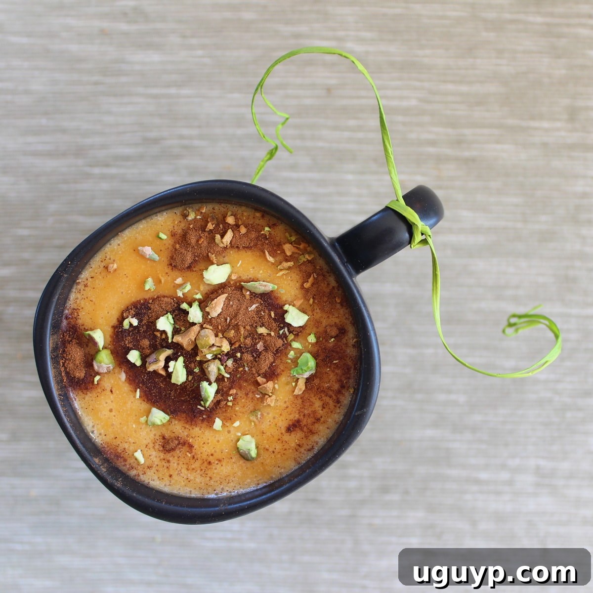 A perfectly prepared Homemade Goguma Latte, steaming gently, with a beautiful topping of cinnamon and crushed pistachios.