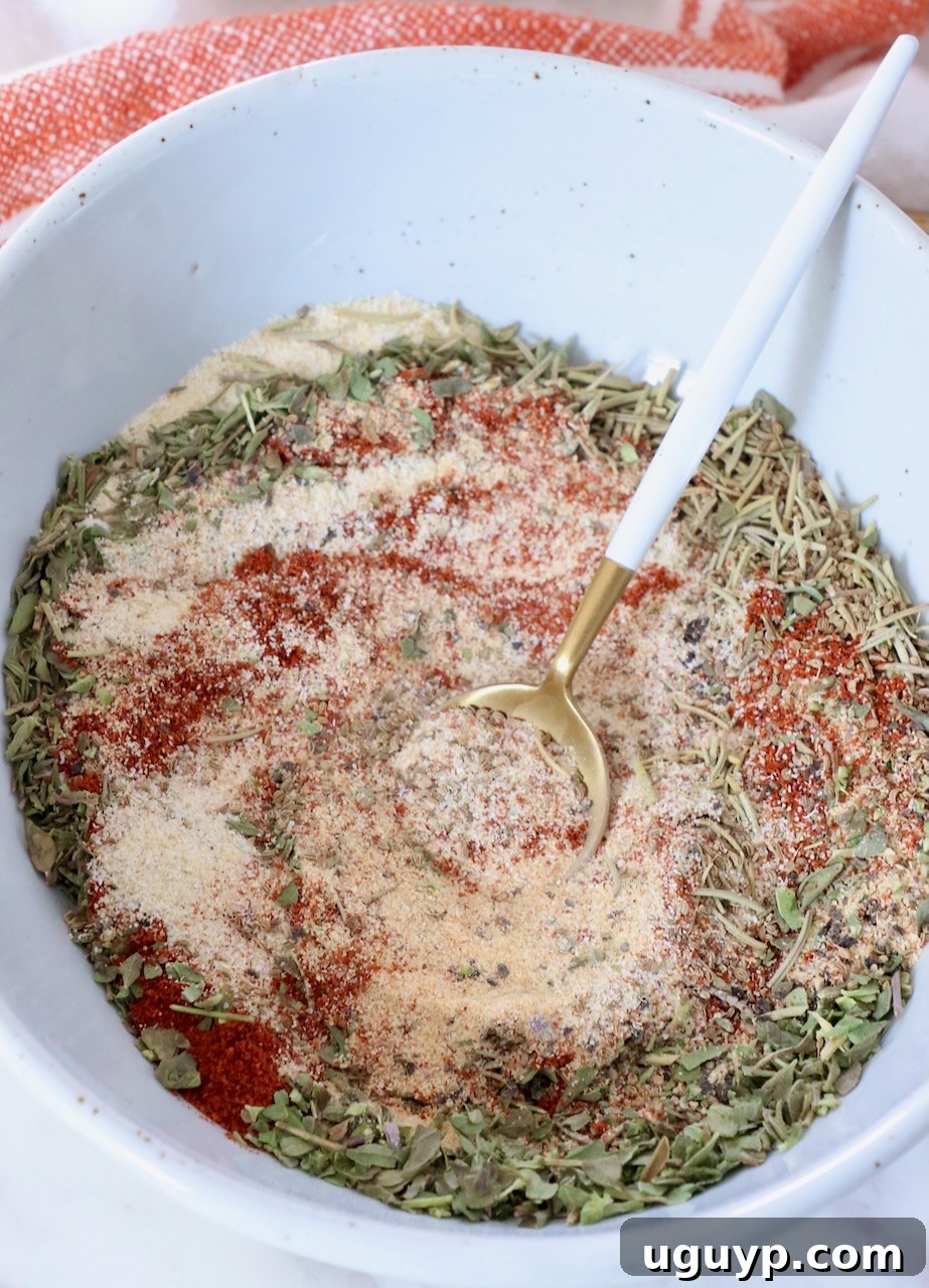 A close-up shot of a variety of dried herbs and spices, combined in a rustic bowl with a small wooden spoon, ready to be used for seasoning a rich beef stew.