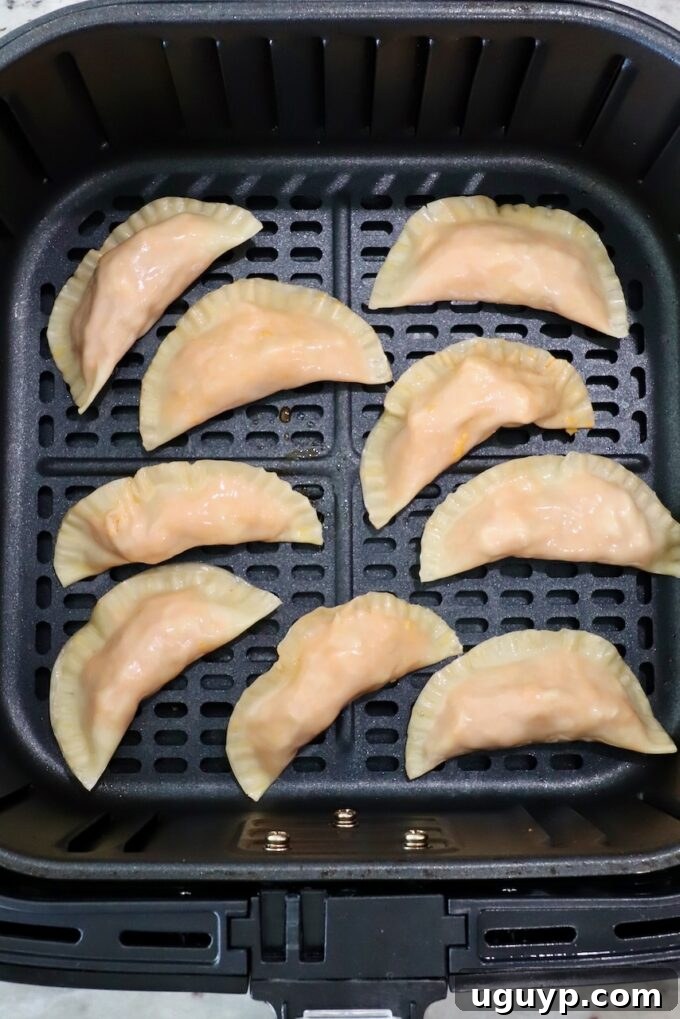 Crispy, golden-brown Buffalo chicken bites arranged in a single layer within an air fryer basket, ready to be served.