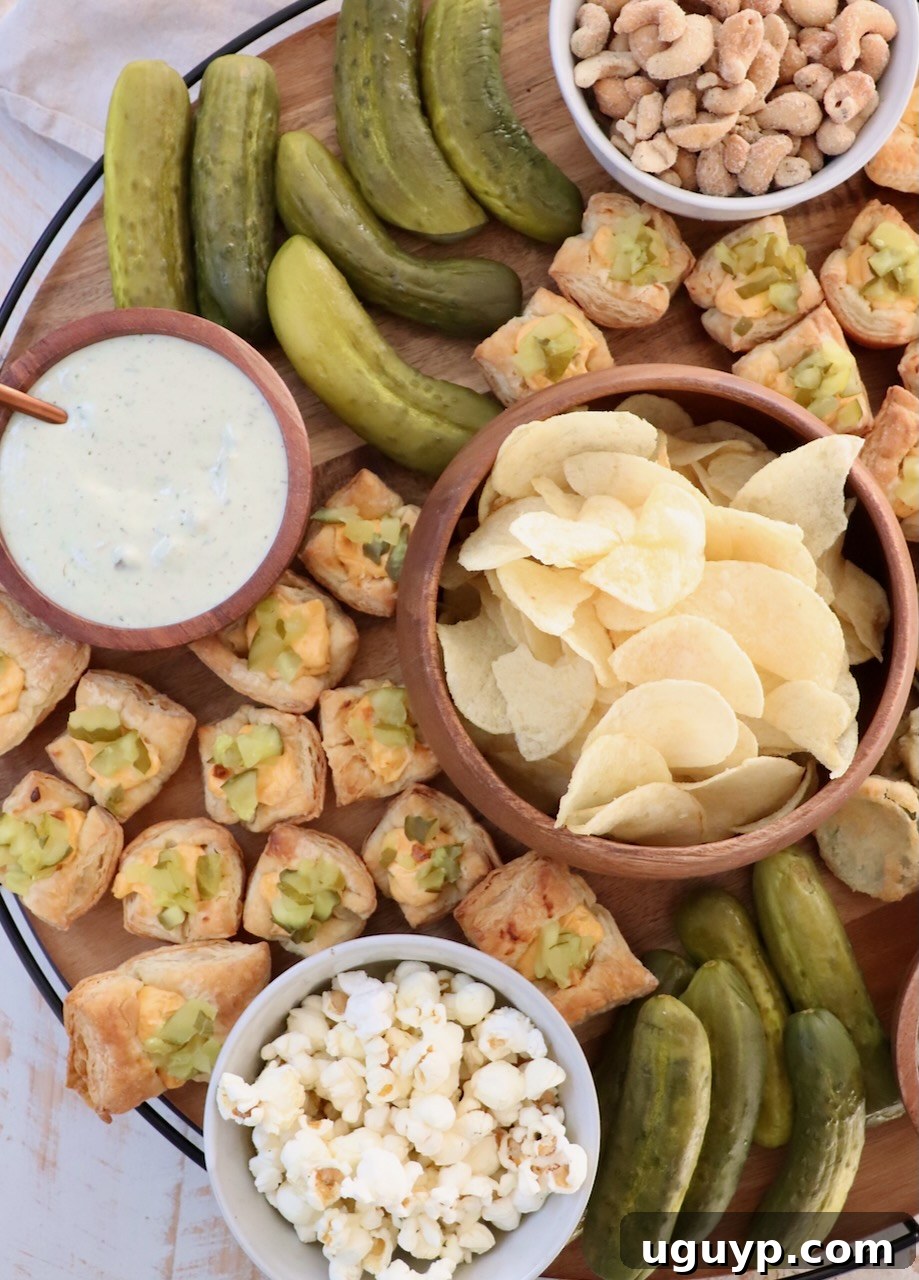 A vibrant board filled with a variety of pickles, pickle-flavored chips, creamy dips, and gourmet popcorn, creating an enticing snack display.