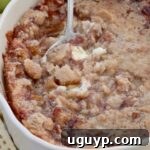 Baked apple pie dip in a baking dish with a serving spoon
