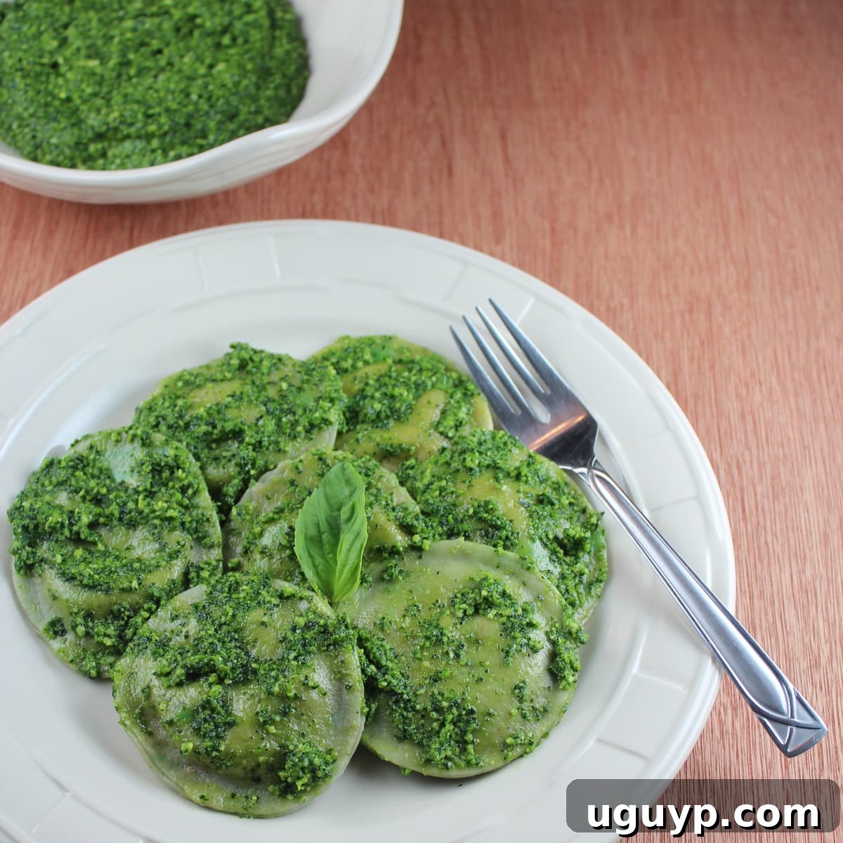 green raviolis on a plate topped with basil pesto