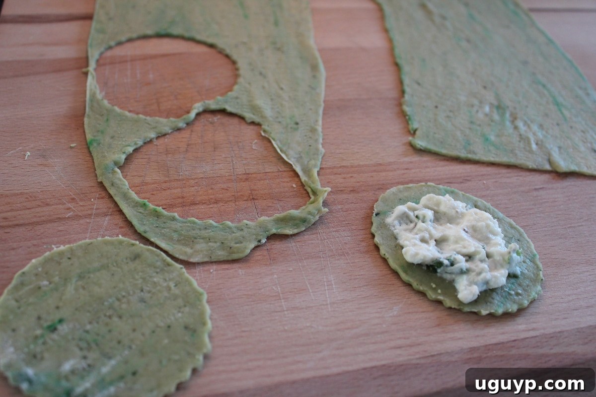ricotta filling on pasta dough on a wood cutting board