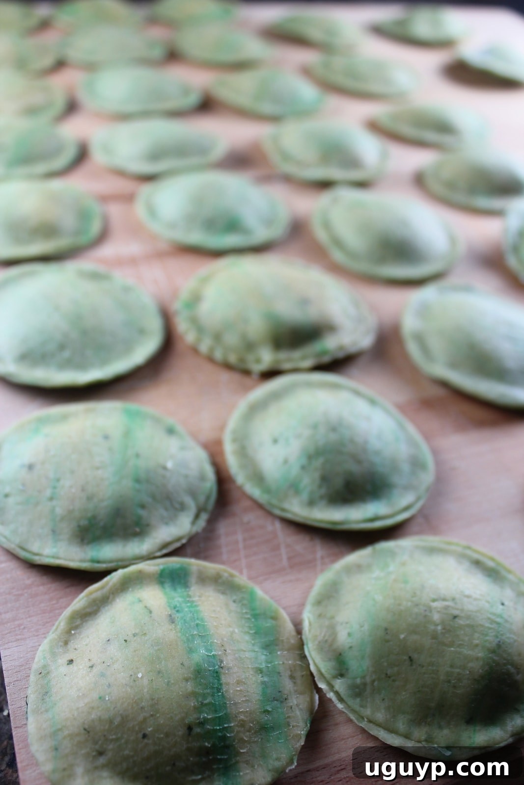 green raviolis on a wood board