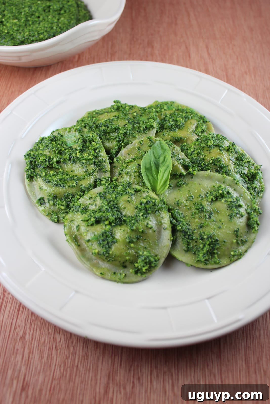 green raviolis with pesto on a plate
