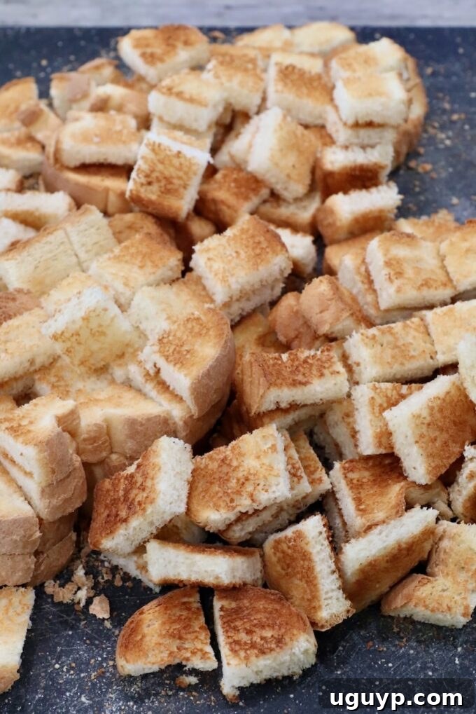 toasted cubes of bread on a cutting board