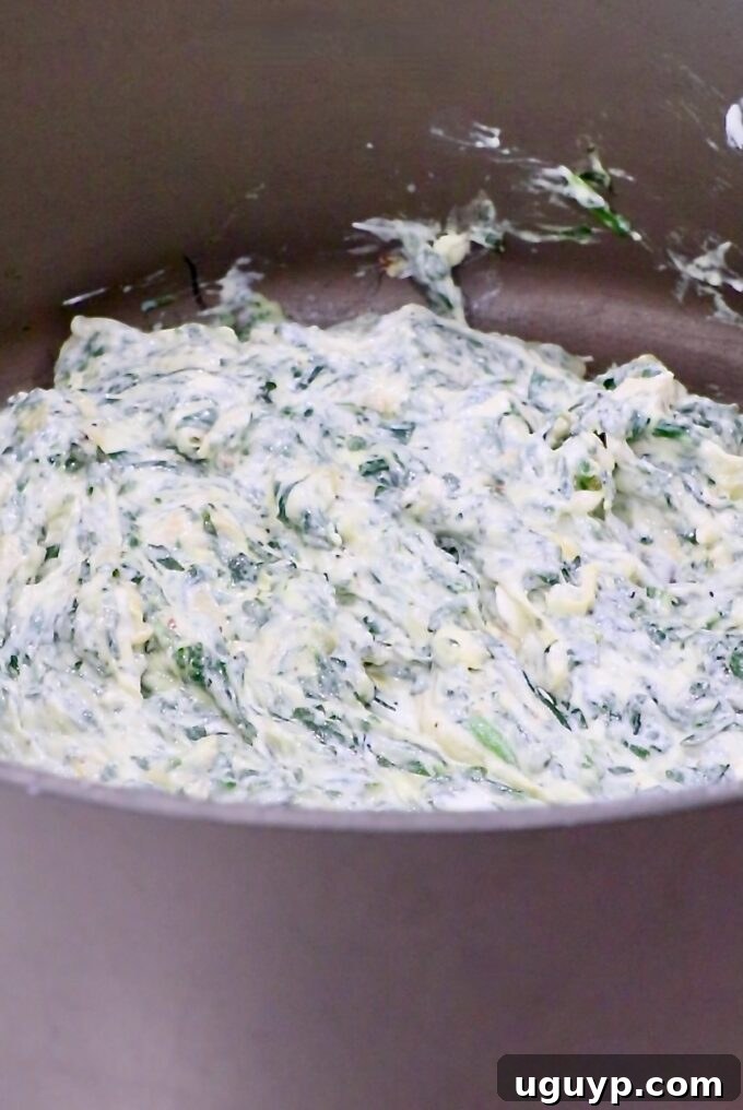 creamy spinach artichoke dip stirred together in a large pot