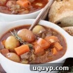 Beef stew with potatoes and carrots in a bowl with a spoon