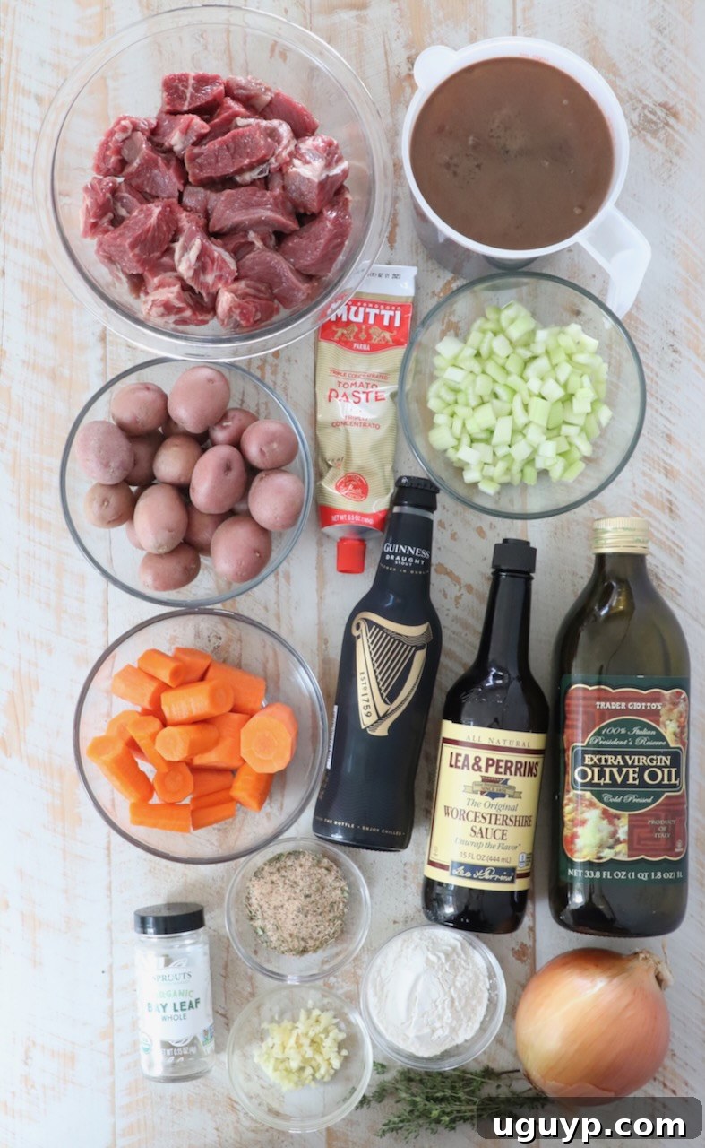 Fresh ingredients for Irish stew laid out on a white wooden board, including diced beef, vegetables, and seasonings.