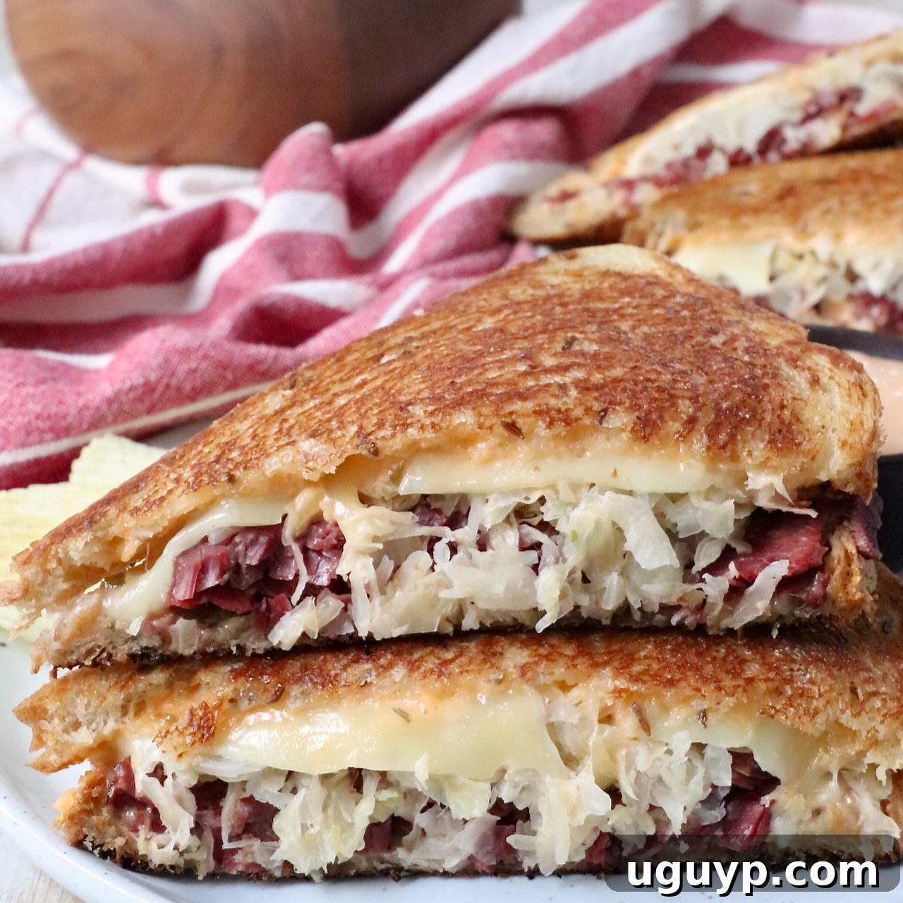 Reuben sandwich sliced in half on a plate