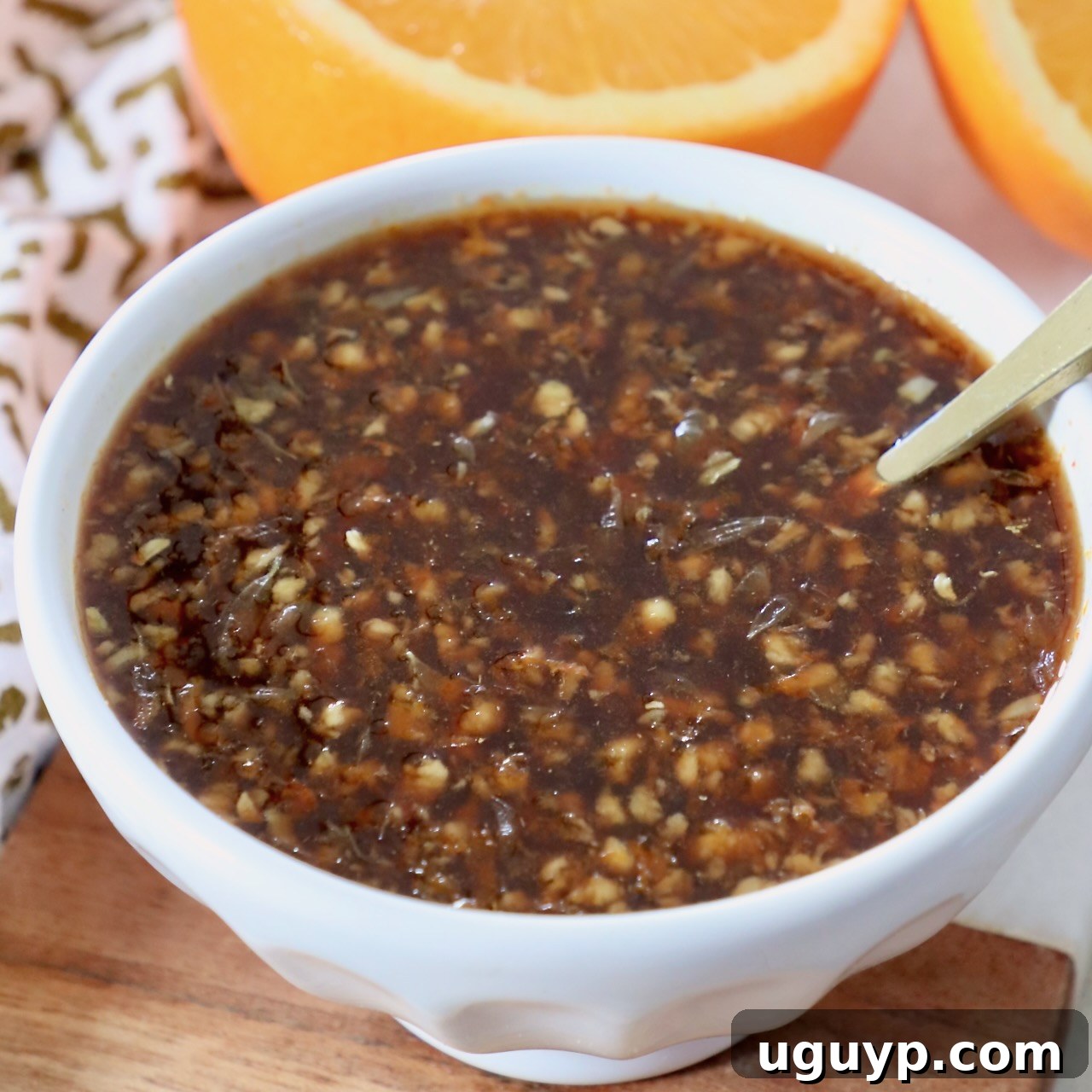 Orange sauce in a small bowl with a spoon
