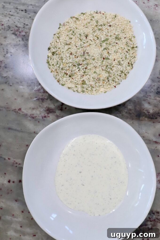 Ranch dressing in a shallow bowl next to Italian seasoned breadcrumbs mixed with Parmesan cheese in another shallow bowl, ready for breading pork chops.