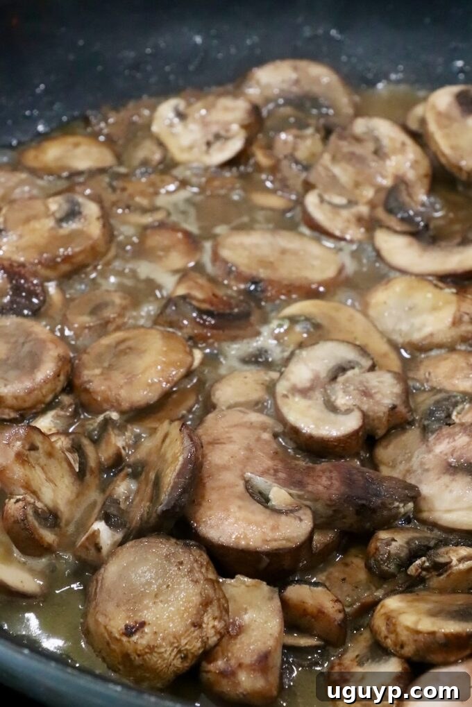 sliced mushrooms cooking in a skillet